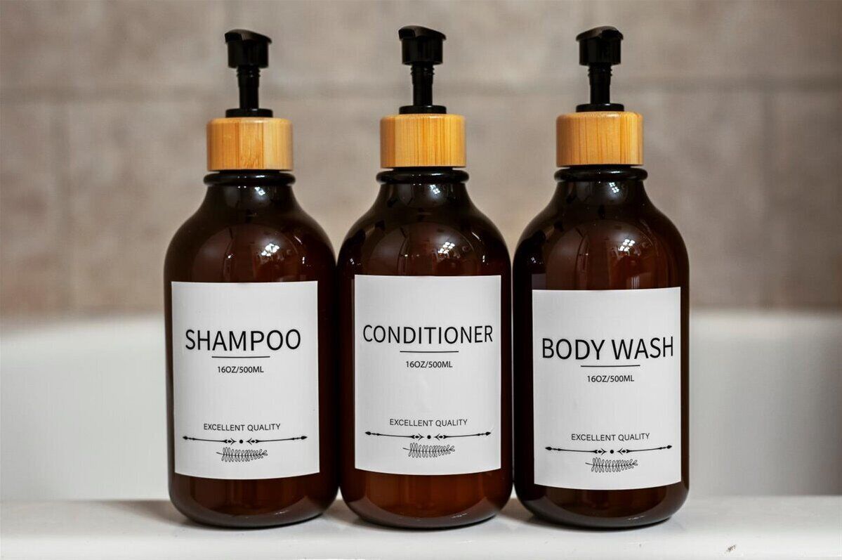 Trois bouteilles de shampoing, d’après-shampoing et de gel douche, dotées de pompes doseuses et d’étiquettes.