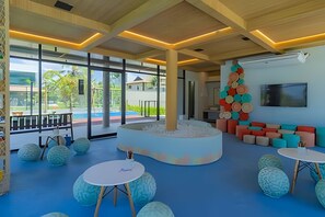 Un interior moderno con una zona de estar central, ventanas amplias y vista a la piscina.