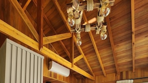 Une chambre de style cabane en bois avec deux lits, un lustre, un appareil de climatisation et une vue sur l’extérieur.