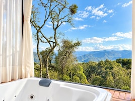 Un baño con bañera y vistas a un paisaje montañoso.
