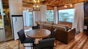 Un intérieur en bois comprenant un coin repas, une cuisine et un espace salon.
