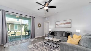 Un salon avec un canapé, une table basse et un ventilateur de plafond.