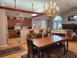 A spacious kitchen with wooden cabinets, a central island, and a dining area with a wooden table and chairs.