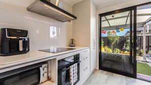 Uma cozinha moderna com forno embutido, micro-ondas e máquina de café.