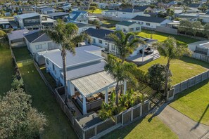 Zona residencial con varias casas, algunas con garajes adjuntos, rodeada de céspedes cuidados y palmeras.