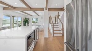 A modern kitchen with a large island, built-in oven, and stainless steel refrigerator. - Silver Lake Hills Home with Views • Patio • Near Sunset Junction (Los Angeles)
