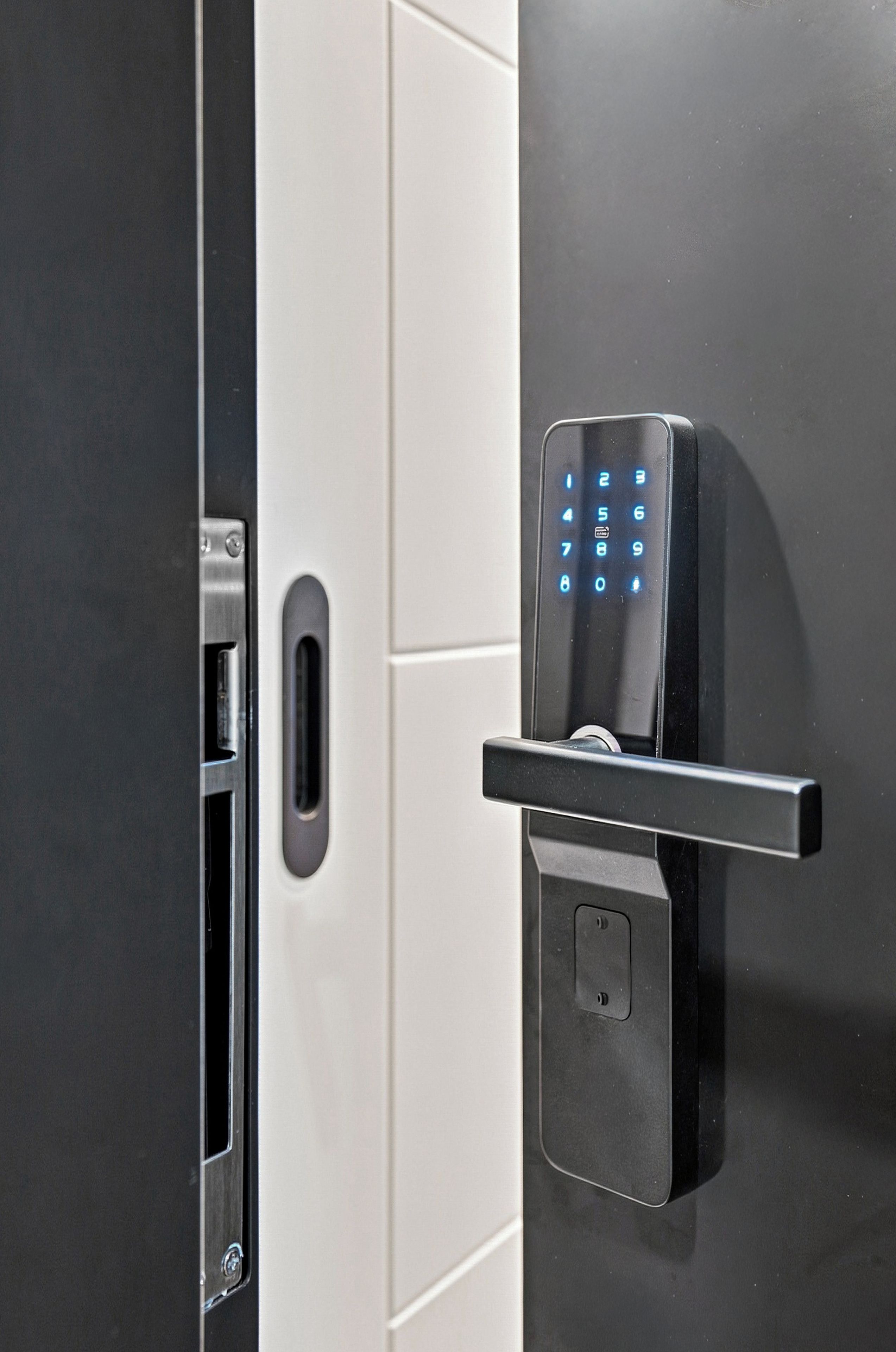 Une porte moderne dotée d’un clavier numérique et d’un lecteur de carte, probablement pour l’accès aux chambres.