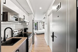 Una cocina moderna con horno empotrado, microondas y cafetera.