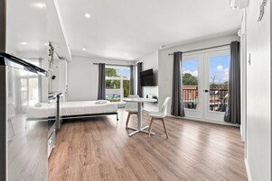 Una habitación de hotel moderna con cama, escritorio y zona de comedor.