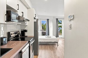 Una cocina moderna con estufa, horno y cafetera.
