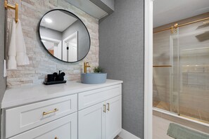 A bathroom with a white vanity, a round mirror, a blue basin, and a glass shower enclosure. - Magical Mickey Retreat, Free Shuttle, Free Parking (Orlando)