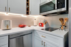 A modern kitchen with white cabinets, a microwave, a toaster, and a dishwasher. - Magical Mickey Retreat, Free Shuttle, Free Parking (Orlando)