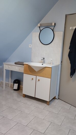 A bathroom with a white sink, a mirror, a towel, and a black trash bin. - Town House in the Heart of the Brenne (Rosnay)