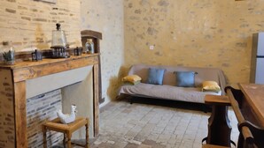 Ein gemütliches Zimmer mit Kamin, einer Couch und einem Holztisch.