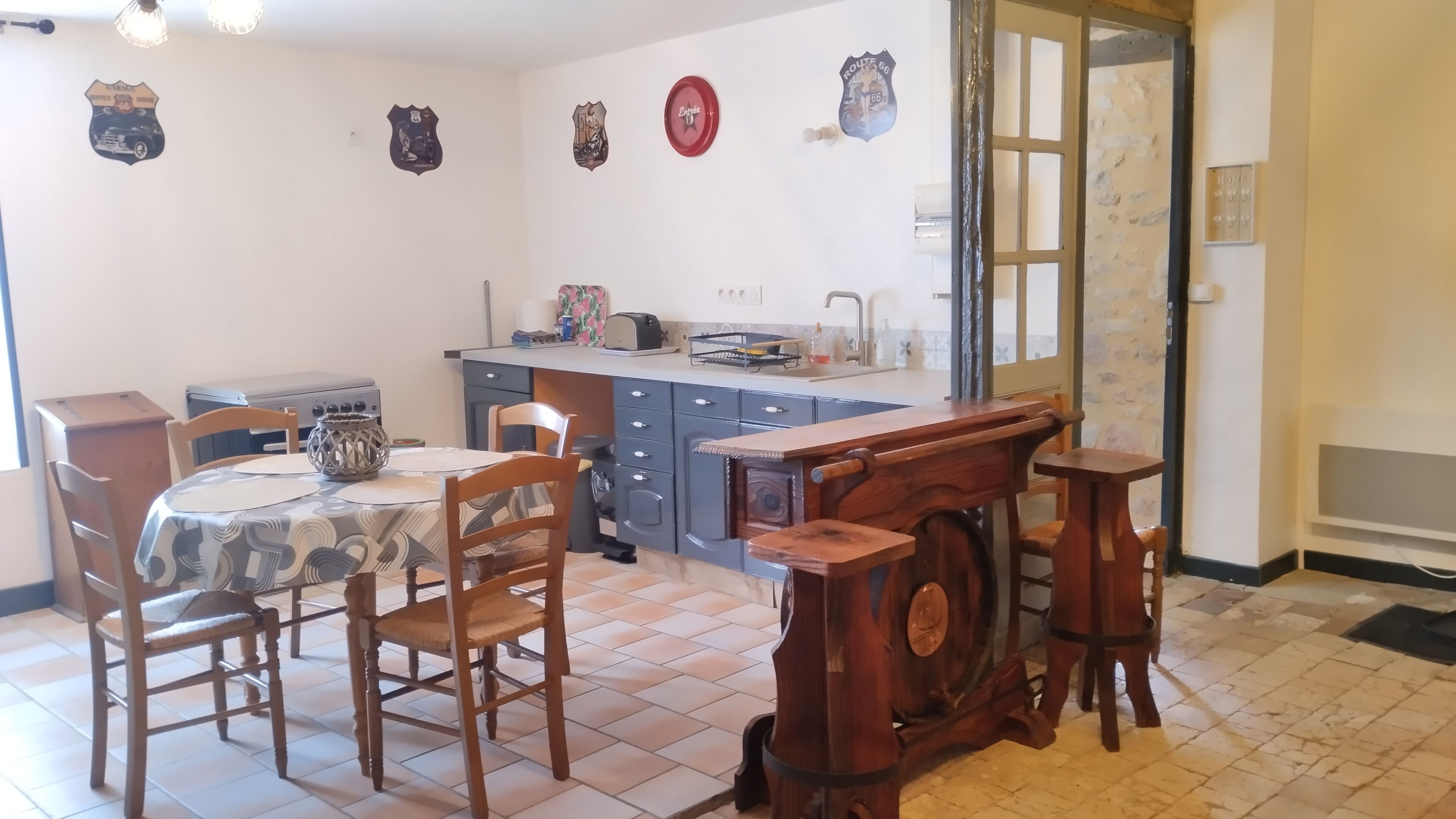 A dining area with a table, chairs, and a kitchen in the background.