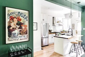Una cocina moderna con armarios blancos, electrodomésticos de acero inoxidable y una isla central.
