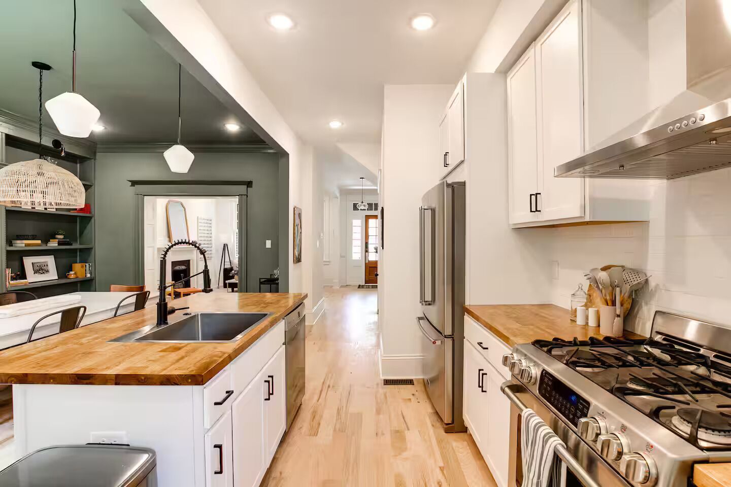 Una cocina moderna con una isla central, electrodomésticos de acero inoxidable y encimera de madera.