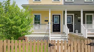 A two-story house with a porch, a black front door, and a mailbox.