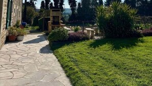 A stone pathway leading to a building with a garden and a clear sky. - Breton longhouse with garden in Trédaniel (Trédaniel)