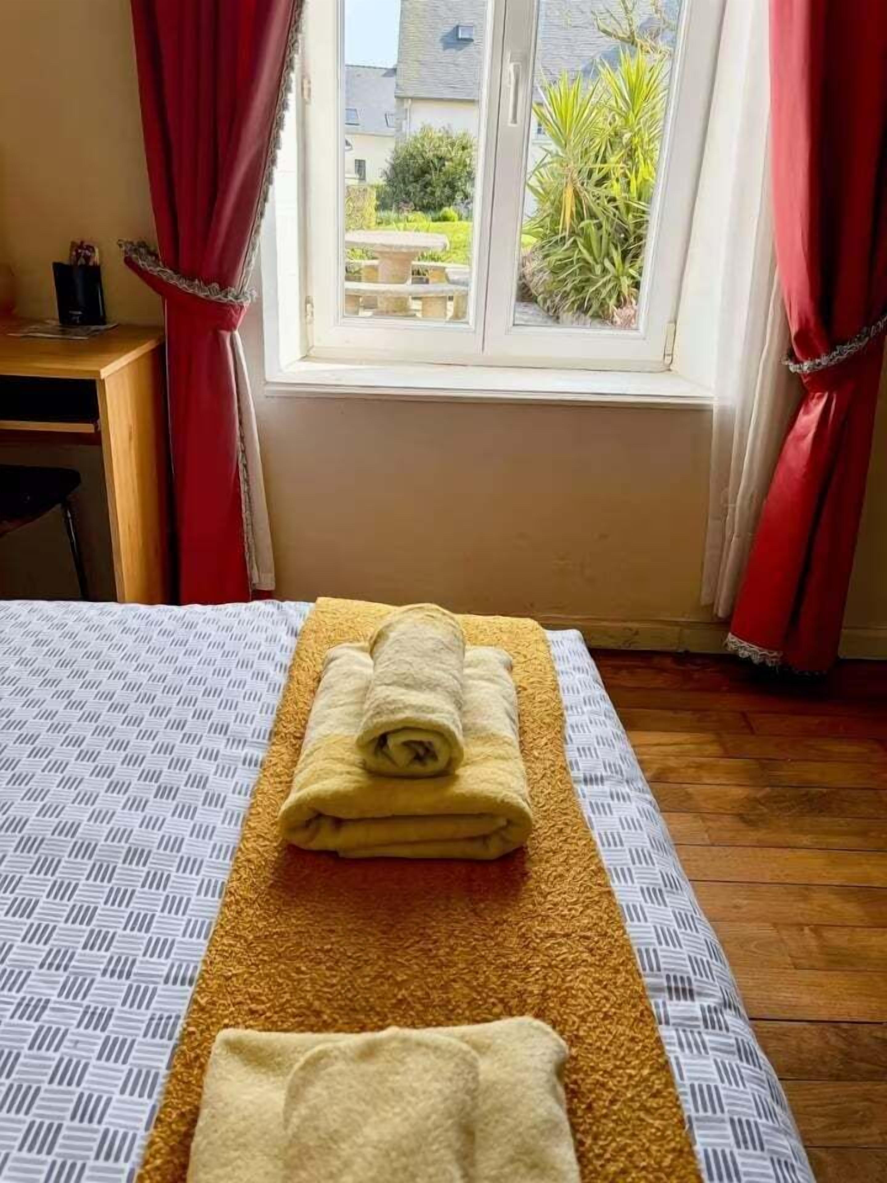 Une chambre d’hôtel avec un lit, une fenêtre avec des rideaux et une vue sur l’extérieur.
