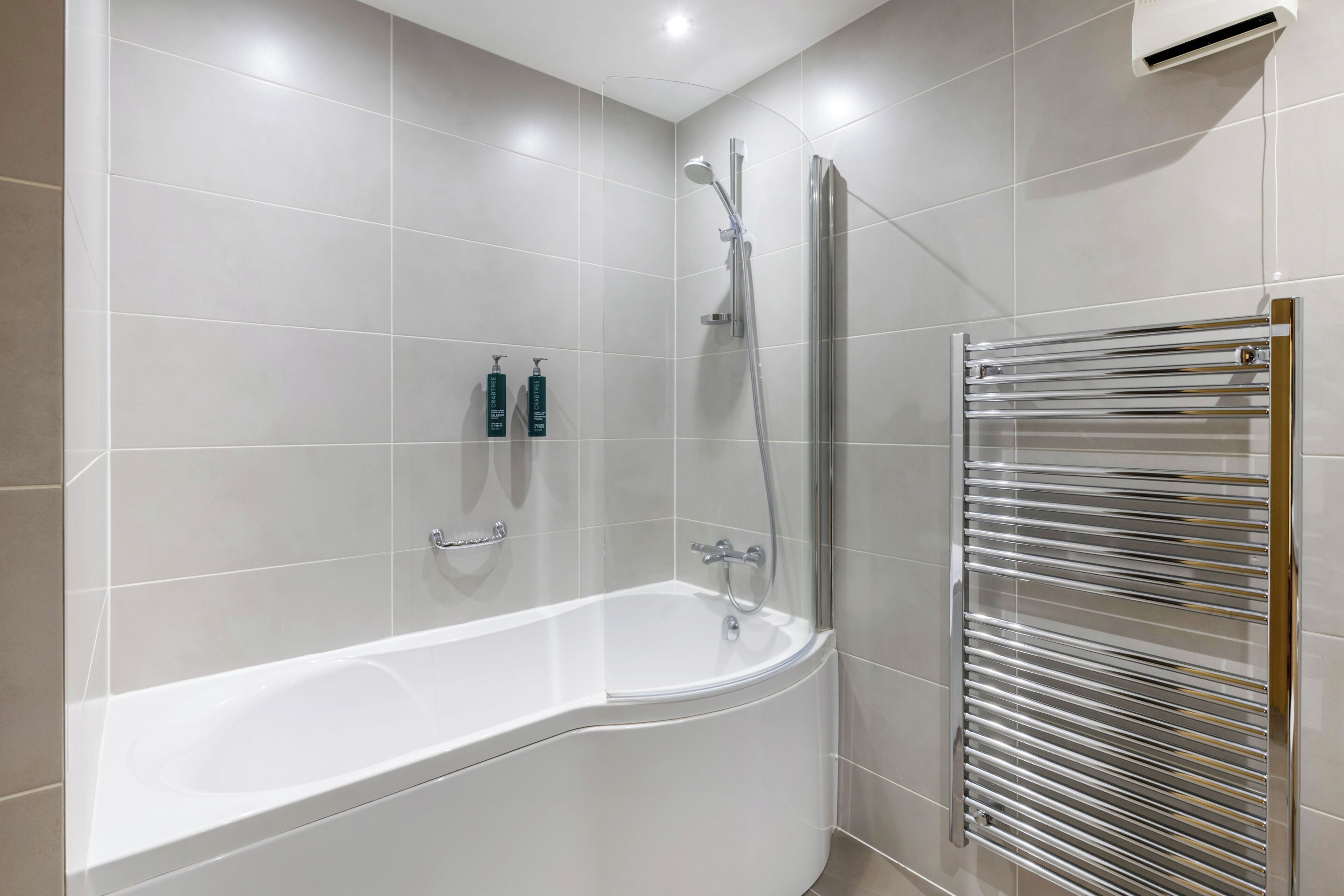 A modern bathroom with a freestanding bathtub, a glass-enclosed shower, and a wall-mounted towel rack.