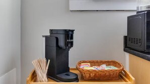 A coffee machine, a microwave, a wicker basket, and a wooden tray in a kitchen. - Walk to VCU & Allianz Amphitheater  Cozy & Clean (Richmond)
