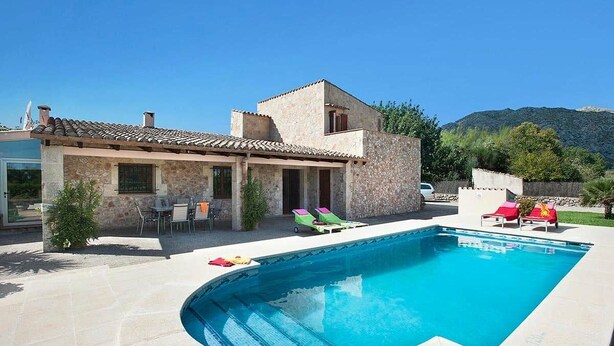 A house with a swimming pool, outdoor furniture, and a stone facade. - Villa Roqueta (Pollença)
