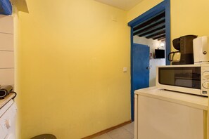 A kitchen with a microwave, coffee maker, and a washing machine. - Apartment 'Way To Castle - Alfama 6' with Wi-Fi and Air Conditioning (Lisboa)