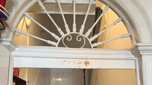 Eine Treppe mit weißer Balustrade, einer Holzhandläufe und einer gefliesten Wand.
