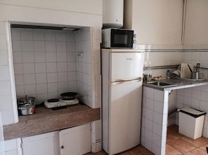 Una cocina compacta con microondas, estufa y refrigerador.