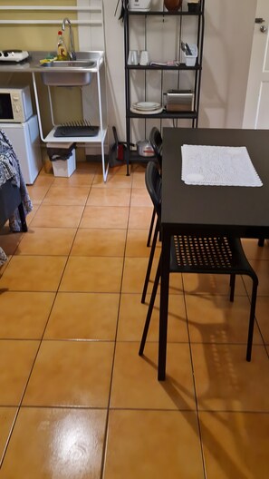 Eine Küche mit Spüle, Herd und einem Esstisch mit Stühlen.