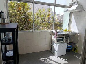 A kitchen with a window, a sink, a microwave, and a small refrigerator. - Apartment '33 - Amoreiras Apartments' with Wi-Fi (Lisboa)