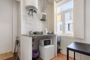 Une cuisine compacte équipée d’un four à micro-ondes, d’une bouilloire et d’un petit réfrigérateur.