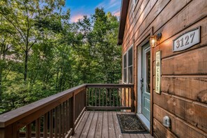 A wooden cabin with a deck, a door with a number plaque, and a mailbox. - Shamrock Valley 1 Bedroom Cabin (Sevierville)