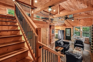 A wooden interior with a staircase, a dining area, and a kitchen. - Shamrock Valley 1 Bedroom Cabin (Sevierville)