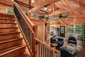 A wooden interior with a staircase, a dining area, and a kitchen. - Shamrock Valley 1 Bedroom Cabin (Sevierville)