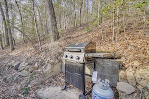 A portable gas grill with a side burner, a propane tank, and a metal cart. - Private Hot Tub! Hillside Smokies Base Camp (Townsend)