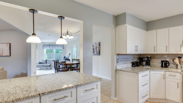 A kitchen with white cabinets, granite countertops, and pendant lighting. - 4 Mi to Garniers Beach Park: Home w/ Private Pool! (Fort Walton Beach)