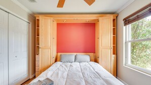A bedroom with a bed, a window, and built-in wooden shelving. - 4 Mi to Garniers Beach Park: Home w/ Private Pool! (Fort Walton Beach)