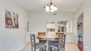 A dining area with a round table, four chairs, and a chandelier. - 4 Mi to Garniers Beach Park: Home w/ Private Pool! (Fort Walton Beach)