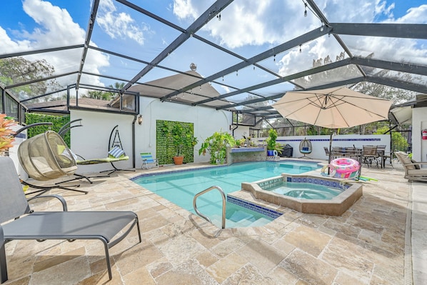 A covered outdoor pool area with a hot tub, lounge chairs, and a pergola. - Poolside Oasis: Group-friendly Getaway in Naples! (Naples)