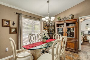 A dining area with a glass table, chairs, a chandelier, and a cabinet with glass doors. - Snowbird Haven! 10 Mi to Warm Mineral Springs Park (North Port)