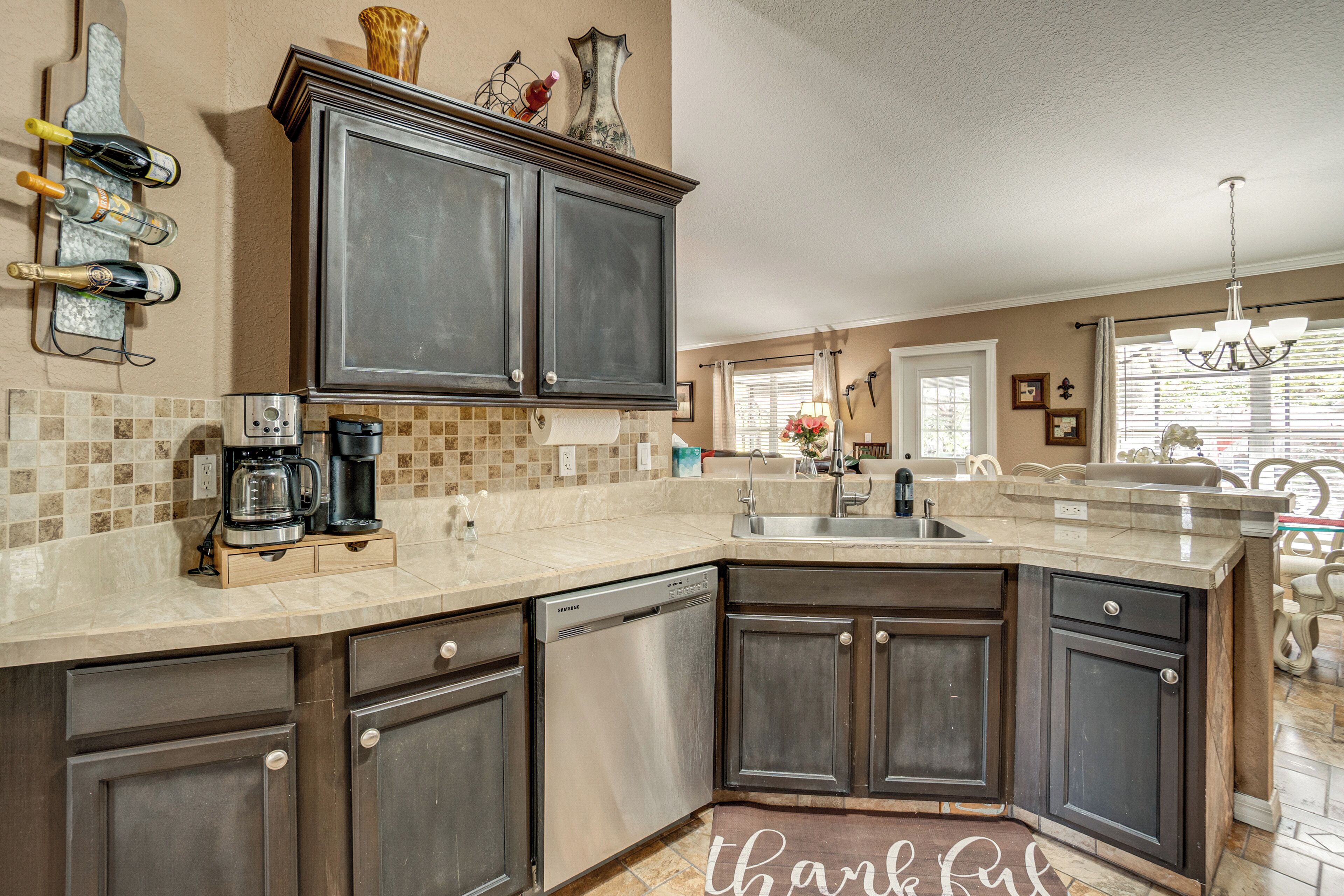 A kitchen with dark cabinets, a coffee maker, and a wine rack.