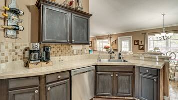 A kitchen with dark cabinets, a coffee maker, and a wine rack.