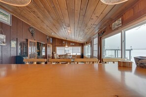 Un interno in legno con un tavolo grande, panche e vista sul lago.