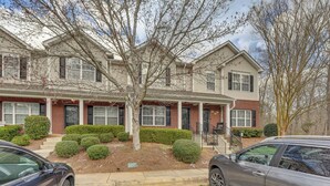 A two-story building with a brick facade and a covered front porch. - Dog-friendly Townhome w/ Patio in Charlotte Area! (Matthews)