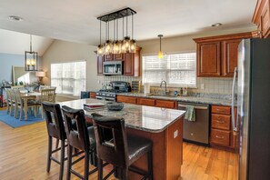 A modern kitchen with a central island, wooden cabinets, and a stainless steel refrigerator. - Community Pool Access! Sleepy Hollow Lake Hideaway (Athens)
