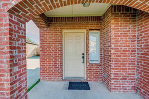 A brick building with a white door, a small window, and a doormat. - Pet Friendly! Renovated Arlington Home Near At&t (Arlington)