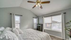 A bedroom with a bed, ceiling fan, windows, and a dresser. - Pet Friendly! Renovated Arlington Home Near At&t (Arlington)