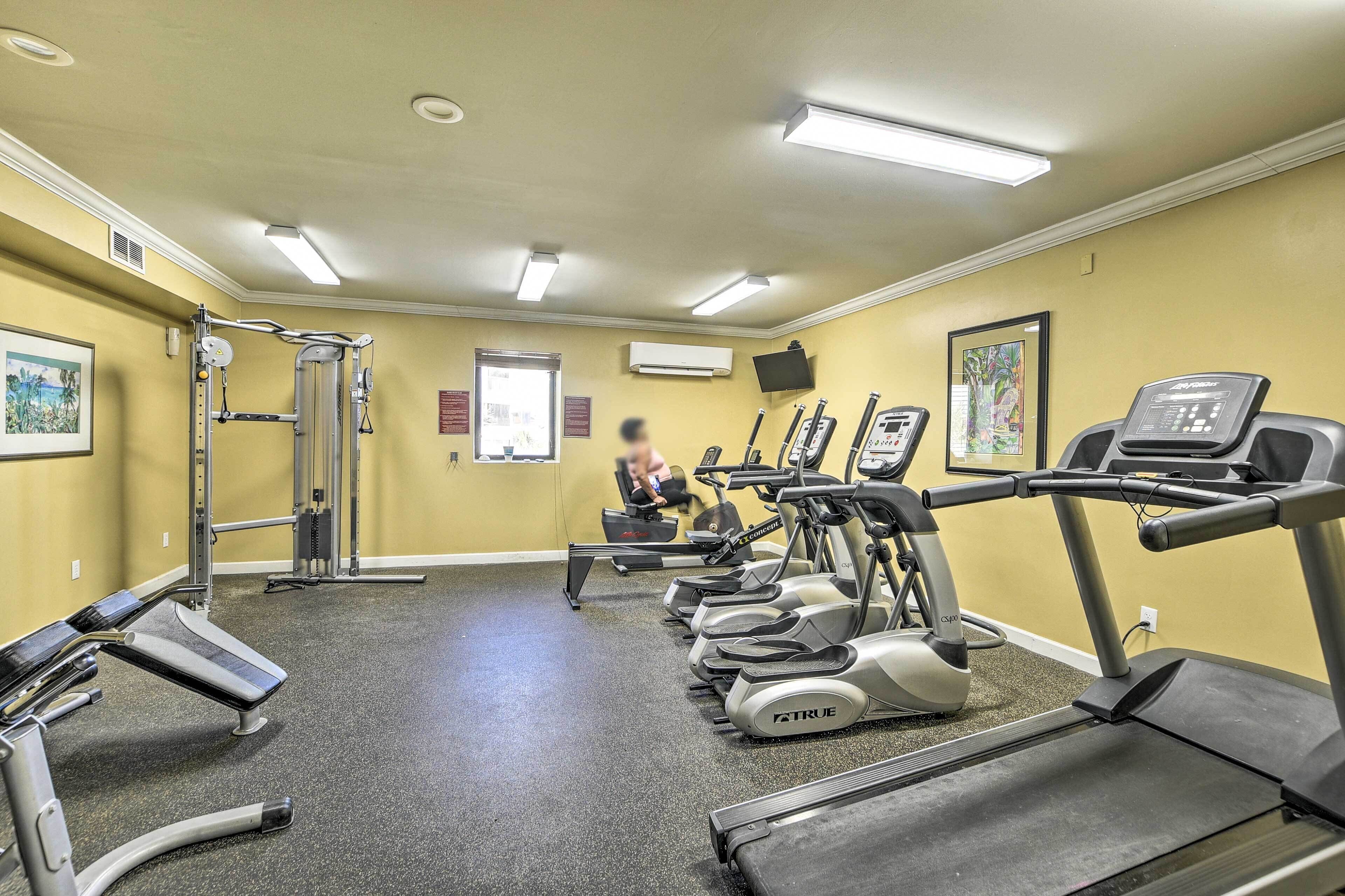 A gym with treadmills, weight machines, and a bench.